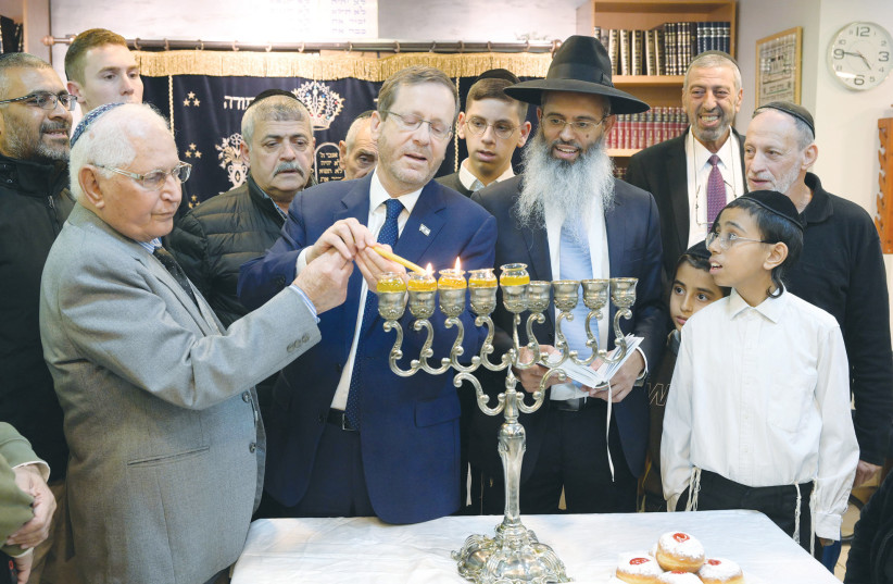  PRESIDENT ISAAC Herzog lights Hanukkah candles in the Moroccan synagogue named for his grandfather, the late Rabbi Isaac Halevi Herzog, in Tel Aviv. (photo credit: AMOS BEN-GERSHOM/GPO)