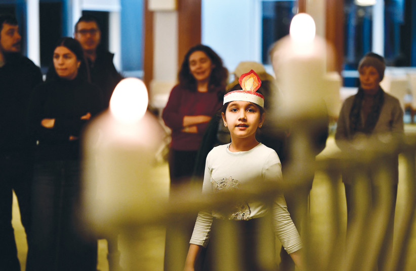  JEWISH REFUGEES from Ukraine celebrate the first night of Hanukkah on Sunday at a kosher shelter in Hungary. The holiday, says the writer, ensures that future generations will similarly be able to celebrate our traditions as Jews. (credit: Marton Monus/Reuters)