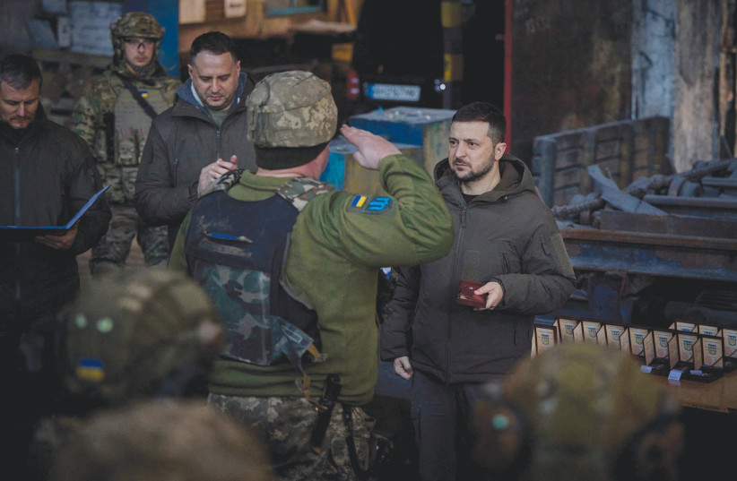  UKRAINE’S PRESIDENT Volodymyr Zelenskiy awards a Ukrainian service member at a position in the frontline town of Bakhmut, in Donetsk region, amid Russia’s attack on Ukraine, on December 20.  (photo credit: UKRAINIAN PRESIDENTIAL PRESS SERVICE/VIA REUTERS TV/HANDOUT VIA REUTERS)