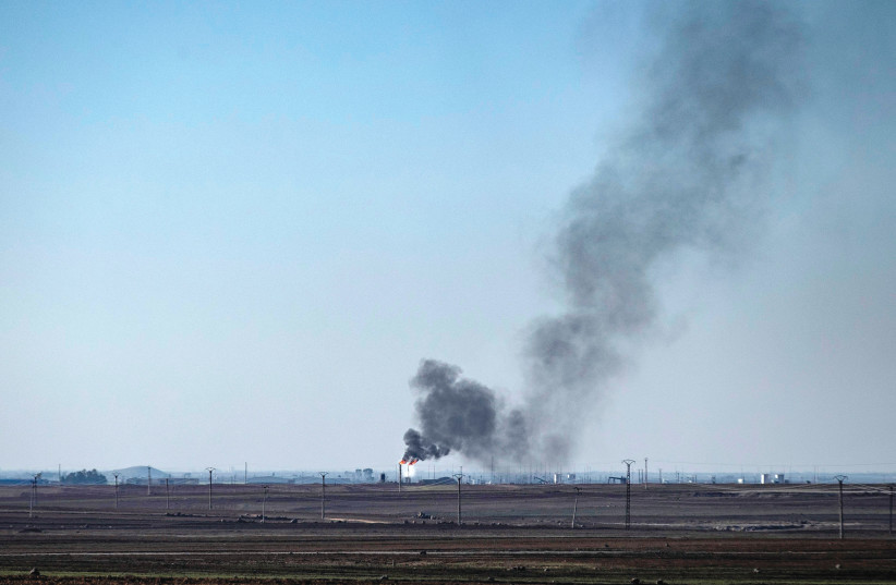  Smoke plumes rise from gas flaring at oil wells in the countryside near the town of al-Qahtaniyah in Syria’s northeastern Hasakah province, close to the border with Turkey on December 18, 2022. (photo credit: DELIL SOULEIMAN/AFP via Getty Images)