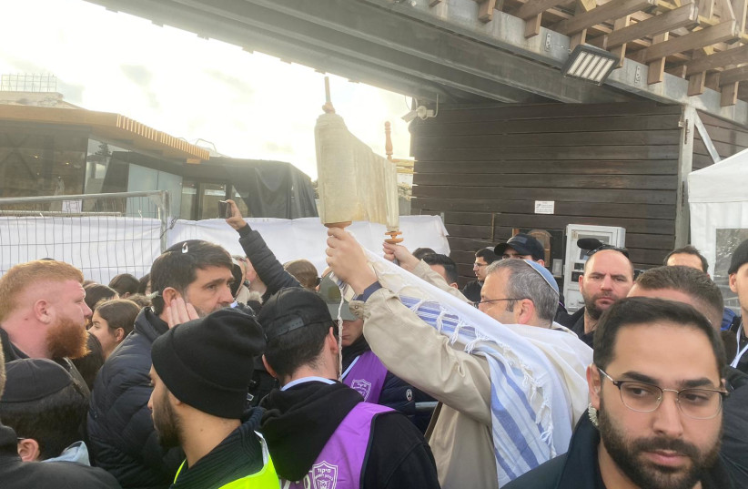  MK Gilad Kariv holds up a Torah scroll at the Western Wall. (credit: WOMEN OF THE WALL)