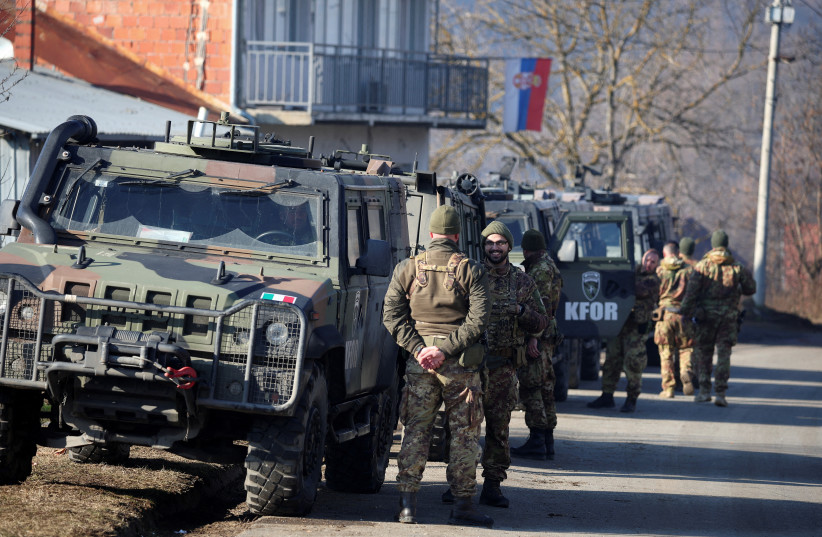  Members of the Italian Armed Forces, part of the NATO peacekeepers mission in Kosovo, stand guard, near a roadblock in Rudare, near the northern part of the ethnically-divided town of Mitrovica, Kosovo, December 27, 2022. (photo credit: REUTERS/FLORION GOGA)