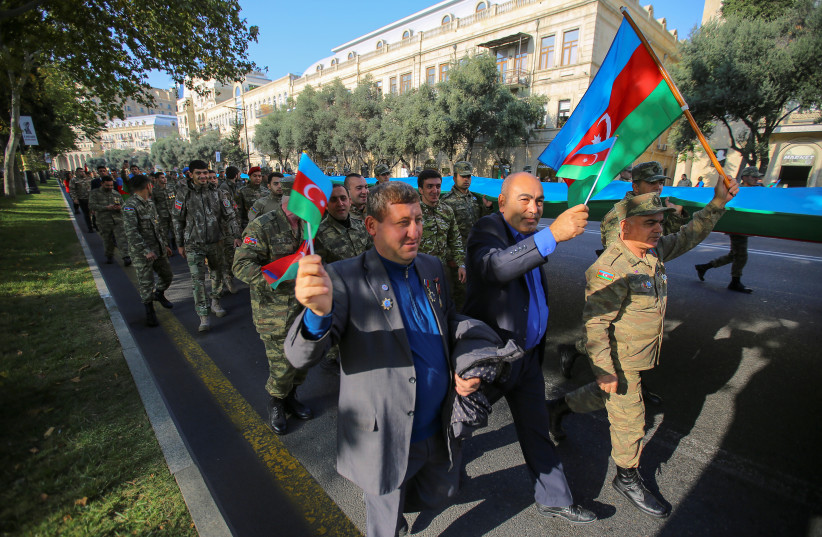  People take part in a procession marking the anniversary of the end of the 2020 military conflict over Nagorno-Karabakh breakaway region, involving Azerbaijan's troops against ethnic Armenian forces, in Baku, Azerbaijan, November 8, 2021. (credit: REUTERS/AZIZ KARIMOV)