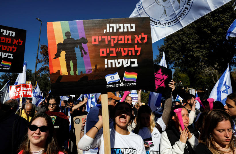  An Israeli holds a sign which says in Hebrew "Netanyahu, we don't abandon LGBTQ's in the field" at a protest outside the Knesset, Israel's parliament, on the day the new right-wing government is sworn in, with Benjamin Netanyahu as Prime Minister, in Jerusalem December 29, 2022. (photo credit: REUTERS/AMMAR AWAD)