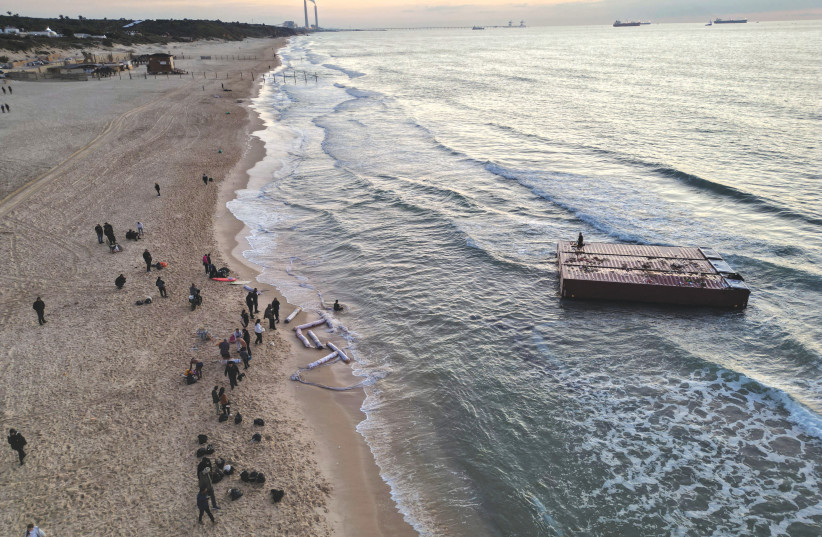  AN AERIAL view shows people gathering near a shipping container that was washed up on the shore in Ashkelon, on Wednesday. (credit: AMIR COHEN/REUTERS)