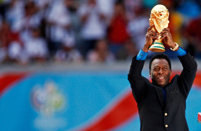  Brazilian soccer legend Pele holds the World Cup trophy during the World Cup 2006 opening ceremony in Munich (credit: REUTERS/DYLAN MARTINEZ/FILE PHOTO)