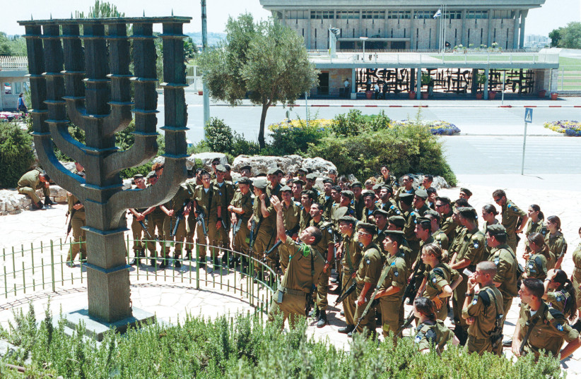  SOLDIERS GATHER in front of the seven-branched candelabrum outside the Knesset, a remembrance of the Temple in Jerusalem. Israel’s Jewish character is reflected in key symbols of the state, says the writer.  (photo credit: NATI SHOHAT/FLASH90)