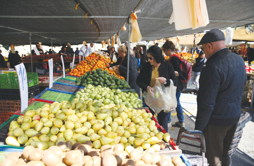 Shoppers buy fruits and vegetables in the market. (credit: DAVID COHEN/FLASH 90)
