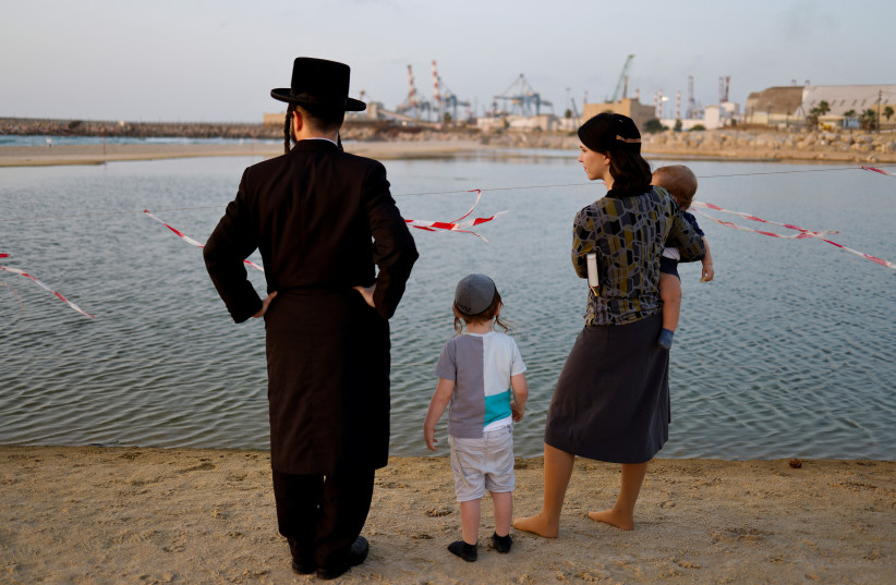 Une famille juive ultra-orthodoxe participe au rituel Tashlikh, pour rejeter symboliquement les péchés, avant Yom Kippour, le jour juif de l'expiation, à Ashdod, Israël, le 3 octobre 2022. (Crédit photo : REUTERS/AMIR COHEN)