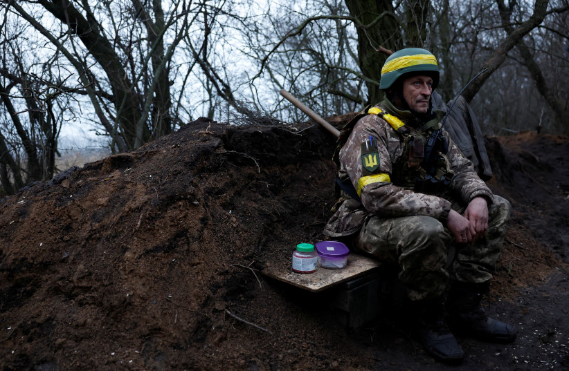  Ukrainian military soldier sits before preparing to fire a mortar round, as Russia's attack on Ukraine continues, in region of Donetsk, Ukraine, December 31, 2022.  (photo credit: REUTERS/CLODAGH KILCOYNE)