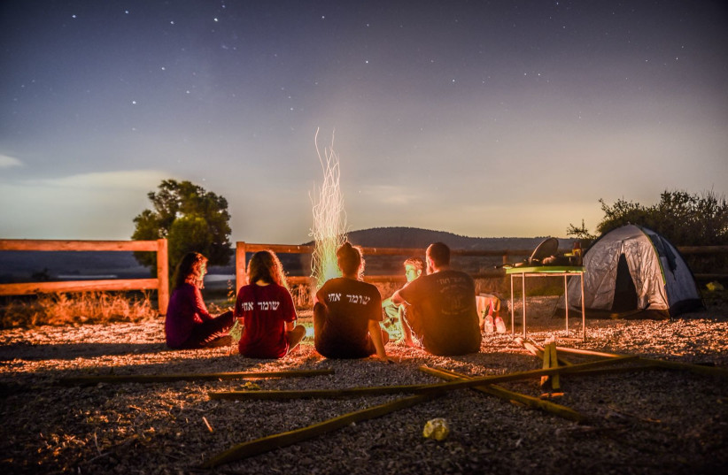   Members of HaShomer HaChadash sit in front of a campfire. (photo credit: Hashomer Hachadash)