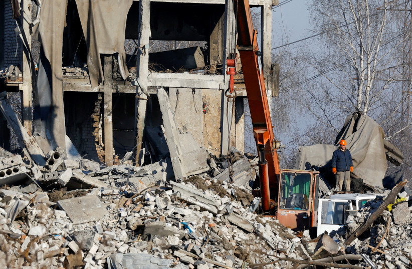  Workers remove debris of a destroyed building, purported to be a vocational college used as temporary accommodation for Russian soldiers, 89 of whom were killed in a Ukrainian missile strike, as stated by Russia's Defence Ministry. (photo credit: REUTERS/ALEXANDER ERMOCHENKO)