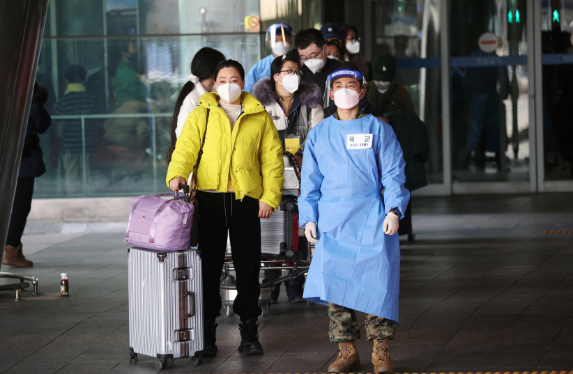 A South Korean soldier wearing personal protective equipment (PPE) leads a group of Chinese tourists for coronavirus disease (COVID-19) testing centre upon their arrival at the Incheon International Airport in Incheon, South Korea, January 4, 2023. (credit: REUTERS/KIM HONG-JI)