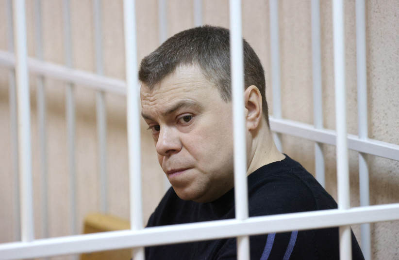 Uladzimir Labkovich, a member of the Viasna human rights group, sits inside a defendants' cage during a court hearing in Minsk, Belarus January 5, 2023. (credit: VITALY PIVOVARCHIK/BelTA/HANDOUT VIA REUTERS)