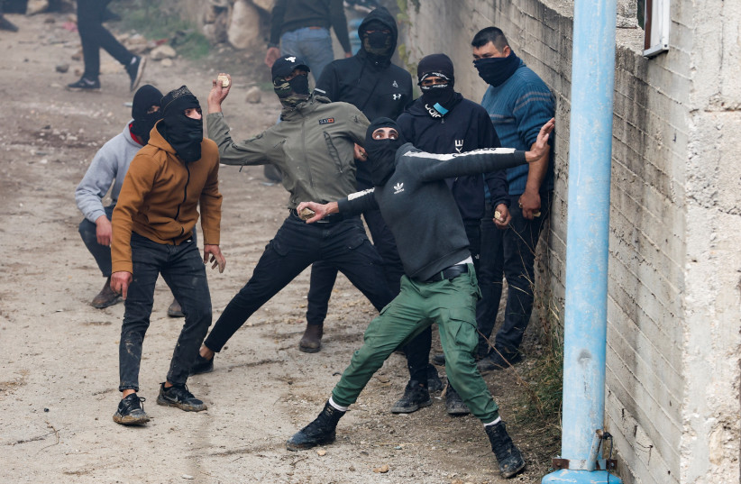  PALESTINIAN DEMONSTRATORS hurl stones during clashes with Israeli forces near Hebron last year. (credit: MUSSA QAWASMA/REUTERS)