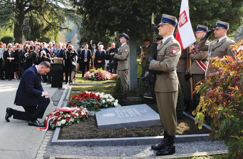  POLISH PRESIDENT Andrzej Duda lays a wreath on the tombstone of a Polish official in Lucerne, Switzerland, in 2018, who saved Jews during World War II.  (photo credit: Arnd Wiegmann/Reuters)