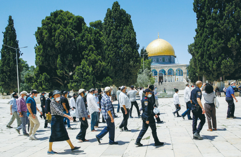  ISRAELI POLICE officers escort a group of religious Jews as they visit the Temple Mount in May 2020. (credit: SLIMAN KHADER/FLASH90)