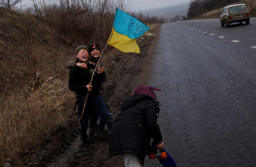  Children play along the side of the road, as Russia's attack on Ukraine continues, in Bakhmut, Ukraine, January 5, 2023 (photo credit: CLODAGH KILCOYNE/REUTERS)
