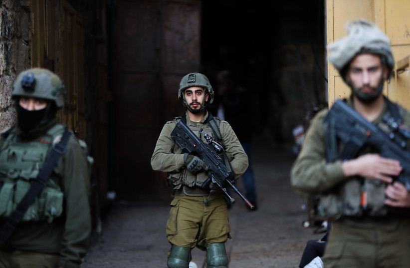  Israeli security forces guard as Jews tour in the West Bank city of Hebron, January 7, 2023. (photo credit: WISAM HASHLAMOUN/FLASH90)