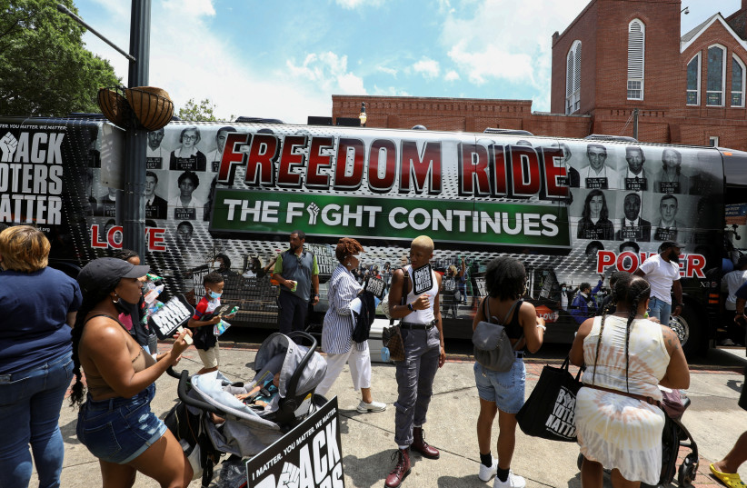  People gather in front of one of the tour buses during a stop on the Freedom Ride For Voting Rights at Ebenezer Baptist Church in Atlanta, Georgia, US June 21, 2021.  (credit: REUTERS/DUSTIN CHAMBERS)