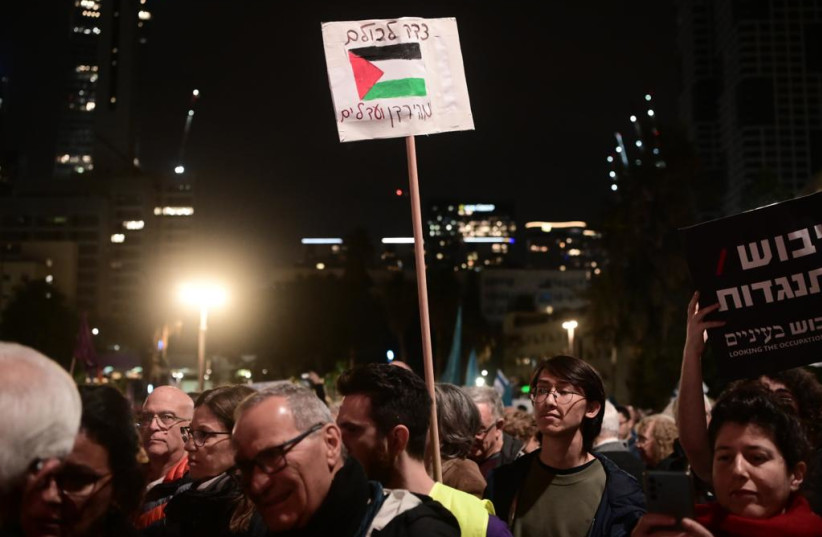 Palestinian flag on sign reading "justice for all from the Jordan to the sea" at anti-Netanyahu protest in Tel Aviv, January 7, 2023 (photo credit: AVSHALOM SASSONI/MAARIV)