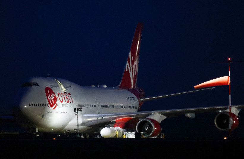 Cosmic Girl, a Virgin Boeing 747-400 aircraft sits on the tarmac with Virgin Orbit's LauncherOne rocket attached to the wing, ahead of the first UK launch tonight, at Spaceport Cornwall at Newquay Airport in Newquay, Britain, January 9, 2023. (photo credit: REUTERS/HENRY NICHOLLS)