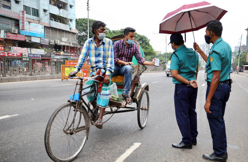  Police officers check commuters at a checkpost during a countrywide lockdown, in Dhaka, Bangladesh, July 1, 2021. (photo credit: REUTERS/MOHAMMAD PONIR HOSSAIN)
