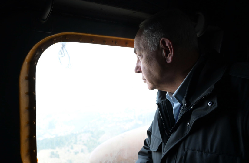  Israeli Prime Minister Benjamin Netanyahu is seen looking out a window during a trip to visit the IDF's Northern Command, on January 10, 2023. (photo credit: AMOS BEN GERSHOM/GPO)