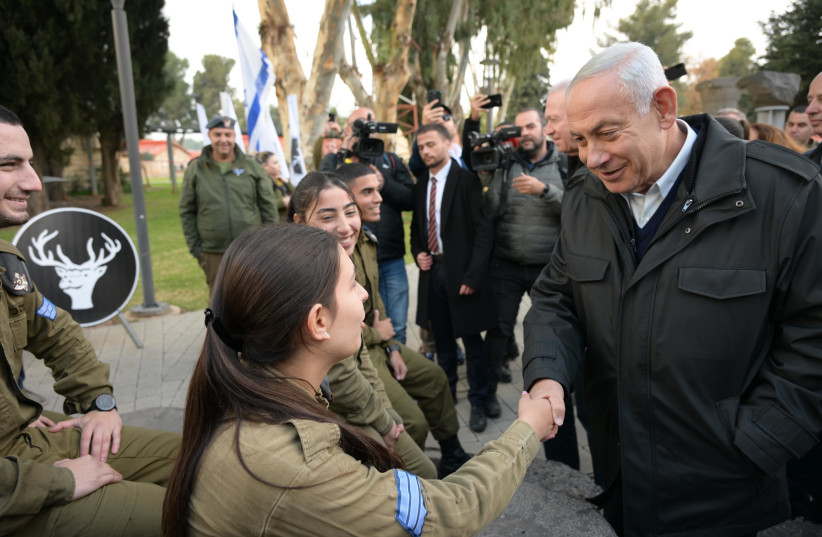  Israeli Prime Minister Benjamin Netanyahu is seen shaking a female IDF soldier's hand while visiting IDF's Northern Command, on January 10, 2023. (credit: AMOS BEN GERSHOM/GPO)