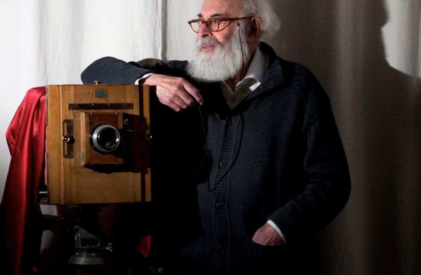  Adolfo Kaminsky poses in front of a camera at his home in Paris, Nov. 16, 2012. (photo credit: Joël Saget/AFP via Getty)