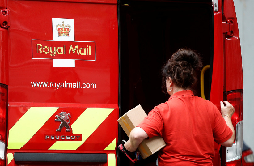  A postal worker makes a delivery in London (photo credit: REUTERS)
