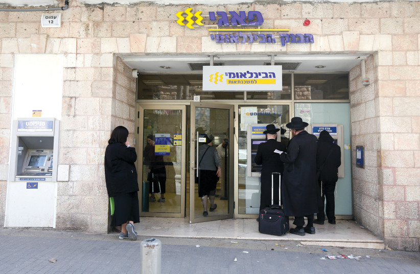  Haredim (ultra-Orthodox Jews) line up outside a bank in Jerusalem’s Geula neighborhood. (photo credit: MARC ISRAEL SELLEM)