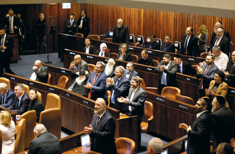  MKs Itamar Ben-Gvir and Bezalel Smotrich (center right behind Arye Deri) applaud at a special session of the Knesset to swear in the new government on December 29, 2022.  (credit: MARC ISRAEL SELLEM)