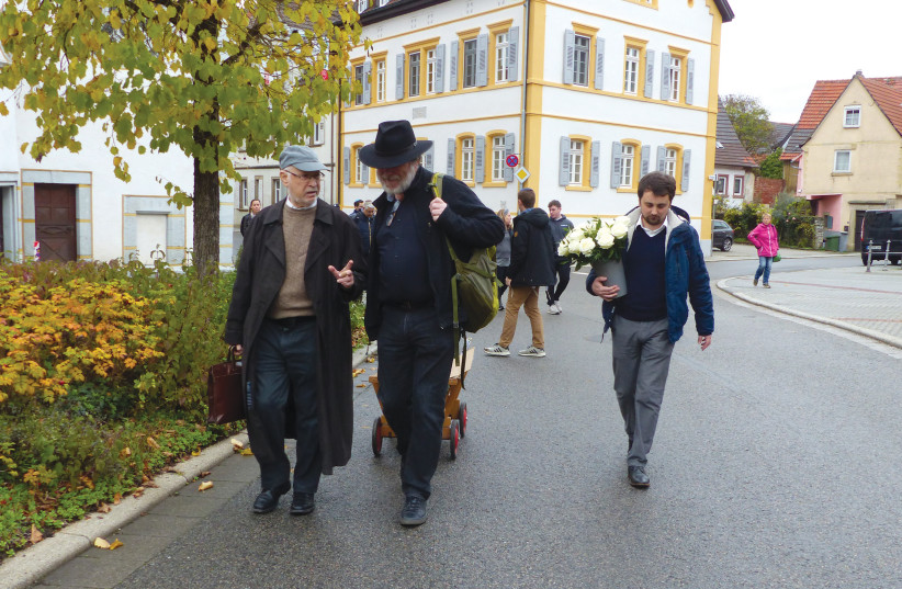  Herr Zeller pulling a wagon with a small suitcase and knapsack. (photo credit: SURA JESELSOHN)