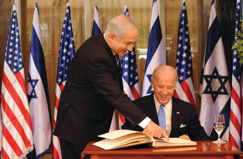  PRIME MINISTER Benjamin Netanyahu helps then-US vice president Joe Biden sign the guestbook at the Prime Minister’s Residence in Jerusalem, 2010.  (photo credit: Debbi Hill/Pool/Getty Images)