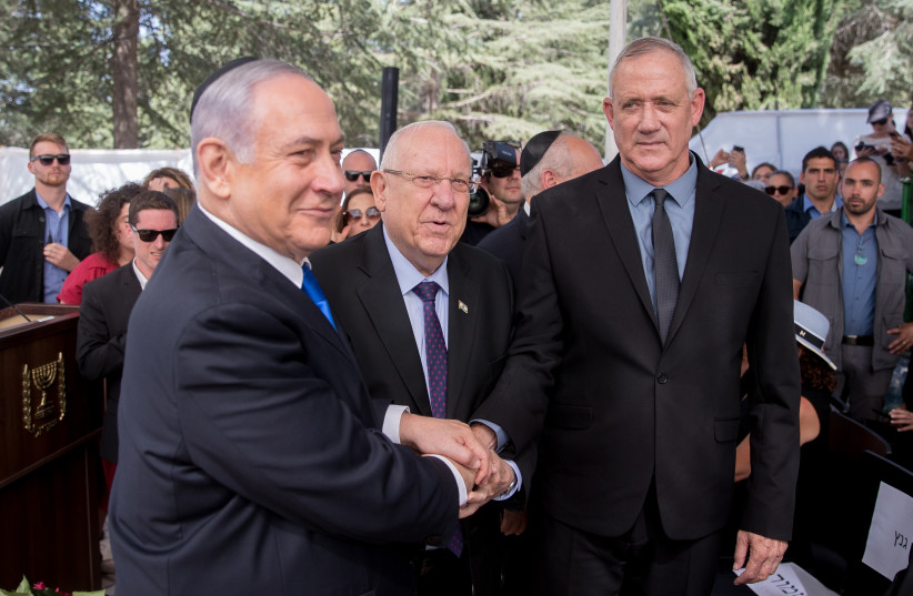  President Reuven Rivlin, Prime Minister Benjamin Netanyahu, and Blue and White leader Benny Gantz, shake hands at the memorial ceremony for the late President Shimon Peres, at the Mount Herzl cemetery in Jerusalem, on September 19, 2019 (credit: YONATAN SINDEL/FLASH90)