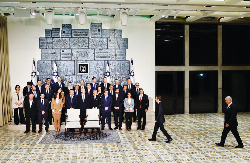  PRESIDENT ISAAC HERZOG, with Prime Minister Benjamin Netanyahu behind him, approaches the members of the new government last month at the President’s Residence.  (photo credit: MARC ISRAEL SELLEM/THE JERUSALEM POST)