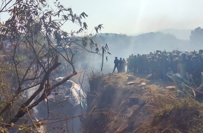  Crowds gather at the crash site of an aircraft carrying 72 people in Pokhara in western Nepal January 15, 2023. (credit: Sagar Raj Timilsina/Handout via REUTERS)