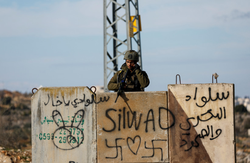 An Israel soldier keeps guard at the scene of a security incident near Ramallah in the West Bank, January 15, 2023.  (photo credit: MOHAMAD TOROKMAN/REUTERS)