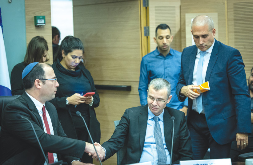  MK SIMCHA ROTHMAN, chairman of the Knesset Constitution, Law and Justice Committee (left), and Justice Minister Yariv Levin shake hands at a committee meeting last week (photo credit: YONATAN SINDEL/FLASH90)