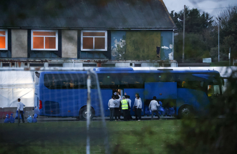  People are seen collecting belongings before boarding a bus inside an immigration processing centre in Manston, Britain, November 2, 2022. (credit: REUTERS/HENRY NICHOLLS)
