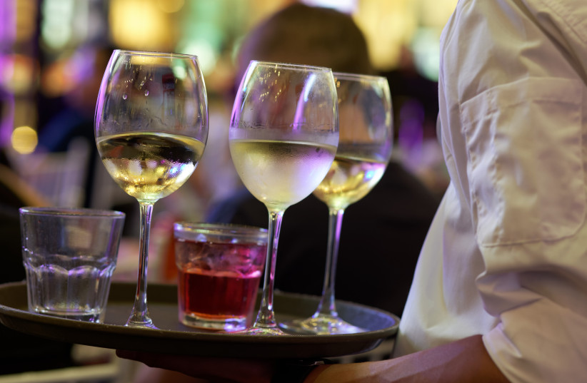  Waiter serves wine to customers (Illustrative) (photo credit: Wikimedia Commons)