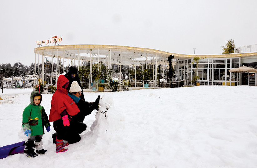  SACHER PARK in snow, Jan. 2022; Gan Sipur cafe is in the background. (photo credit: OLIVIER FITOUSSI/FLASH90)