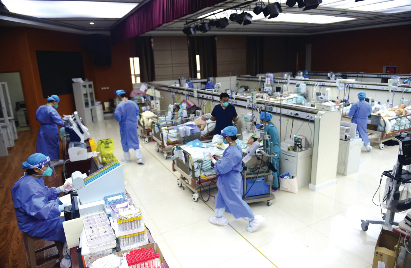  MEDICAL WORKERS attend to COVID-19 patients at an intensive care unit converted from a conference room, at a hospital in Cangzhou, in the Hebei province of China, last week.  (photo credit: REUTERS)