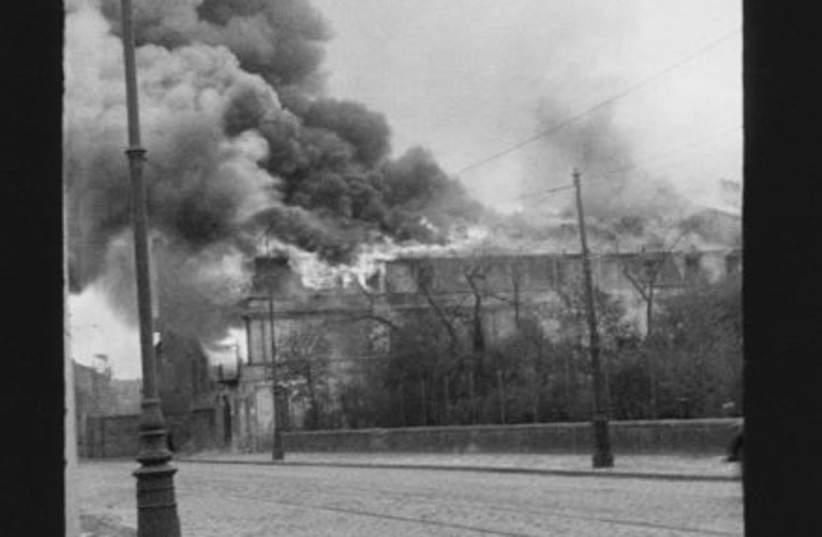  Smoke and fire seen at the Warsaw Ghetto in the aftermath of the Warsaw Ghetto Uprising in 1943. (credit: Z. L. Grzywaczewski/Family archive of Maciej Grzywaczewski/print from the negative: POLIN Museum)