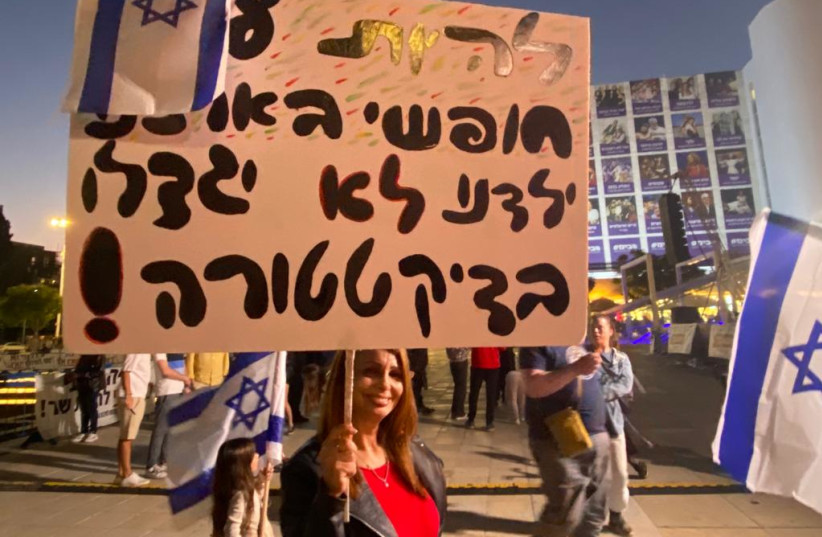Woman carries sign reading ''to be a free people in our country. Our children won't grow up in a dictatorship.''  (credit: AVSHALOM SASSONI/MAARIV)