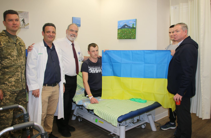  Right to left: Ukrainian Ambassador Yevgen Korniychuk, Ukrianian soldiers holding a flag, Dr. Hagai Amir, Dr. Sergey Kotikov, and the military annex of the embassy. (photo credit: PUBLIC RELATIONS)
