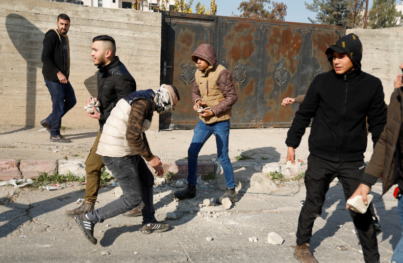 Palestinian stone-throwers gather amid clashes with Israeli troops during a raid in Jenin in the West Bank January 26, 2023 (credit: REUTERS/RANEEN SAWAFTA)
