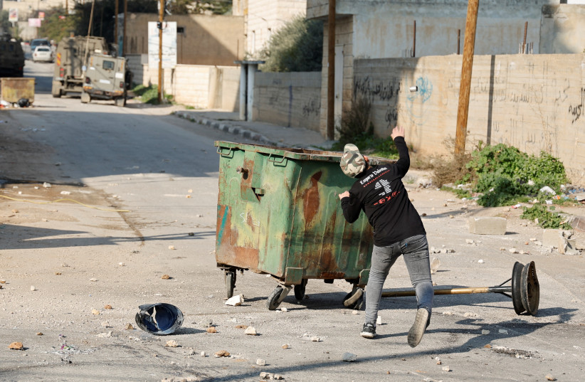 Palestinian stone-throwers gather amid clashes with Israeli troops during a raid in Jenin in the West Bank January 26, 2023 (credit: REUTERS/RANEEN SAWAFTA)