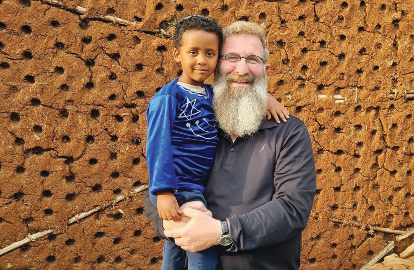 RABBI ELIAHU BIRNBAUM avec un enfant juif nigérian. (crédit : Instituts Straus-Amiel et Ohr Torah-Nidchei Yisrael)